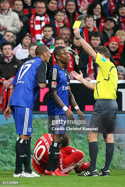 Referee Lutz Wagner shows Jérome Boateng of Hamburg the yellow card during the Bundesliga match between FC Bayern Muenchen and Hamburger SV at...