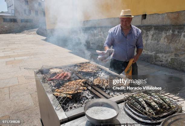 Restaurante Alfandega" cook grills sardines, beef and other fish over charcoal by Ave River on May 28, 2018 in Vila do Conde, Portugal. Grilled...