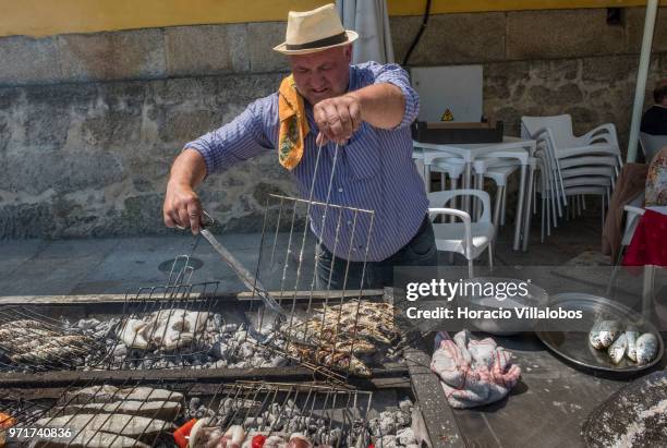 Restaurante Alfandega" cook grills sardines, beef and other fish over charcoal by Ave River on May 28, 2018 in Vila do Conde, Portugal. Grilled...