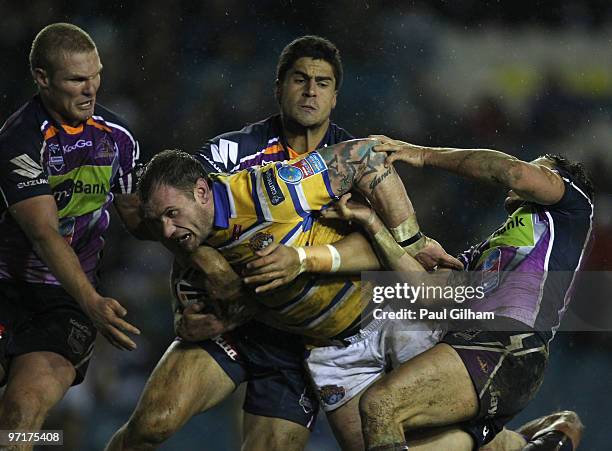 Jamie Peacock of Leeds Rhinos is tackled by Todd Lowrie , Jesse Bromwich , and Billy Slater of Melbourne Storm during the World Club Challenge match...