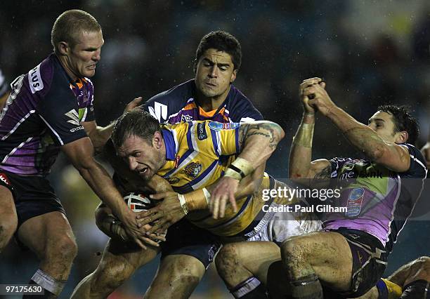 Jamie Peacock of Leeds Rhinos is tackled by Todd Lowrie , Jesse Bromwich , and Billy Slater of Melbourne Storm during the World Club Challenge match...
