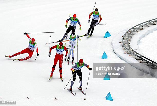 Dario Cologna of Switzerland crashes to the snow as Petter Northug of Norway competes on his way to winning the gold medal from Axel Teichmann of...