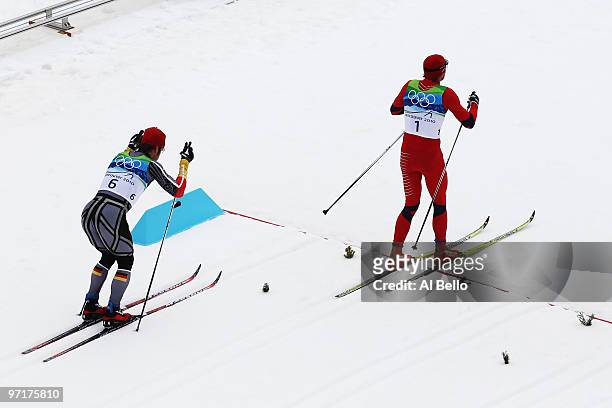 Gold medalist Petter Northug of Norway crosses the line ahead of Axel Teichmann of Germany during the Men's 50 km Mass Start Classic cross-country...