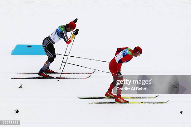 Gold medalist Petter Northug of Norway passes Axel Teichmann of Germany during the Men's 50 km Mass Start Classic cross-country skiing on day 17 of...