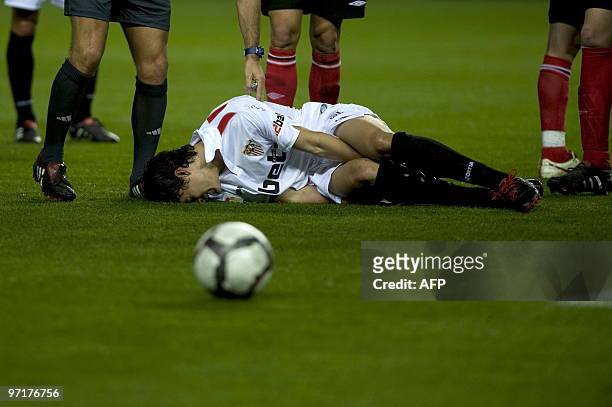 Sevilla's Argentinian midfielder Diego Perotti gestures in pain during a Spanish league football match against Athletic Bilbao at Sanchez Pizjuan...