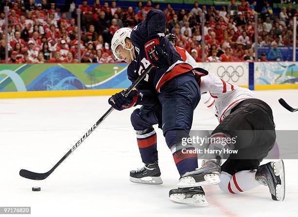 Dustin Brown of the United States holds off the challenge from Drew Doughty of Canada during the ice hockey men's gold medal game between USA and...