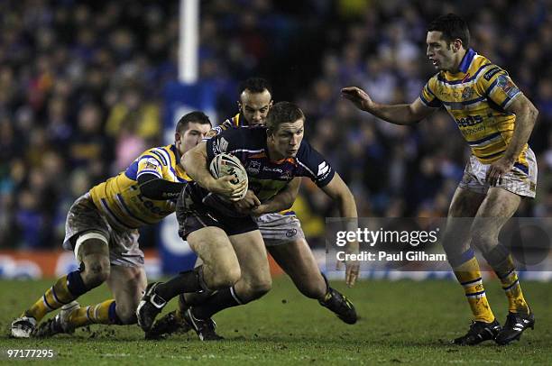 Ryan Hoffman of Melbourne Storm is tackled by Brett Delaney, Jamie Jones-Buchanan and Danny Buderus of Leeds Rhinos during the World Club Challenge...