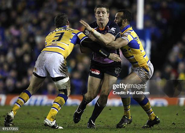 Ryan Hoffman of Melbourne Storm is tackled by Brett Delaney and Jamie Jones-Buchanan of Leeds Rhinos during the World Club Challenge match between...