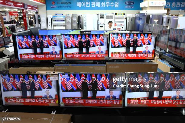 President Donald Trump meeting with North Korean leader Kim Jong-un is shown on television screens at an electronics retail store on June 12, 2018 in...