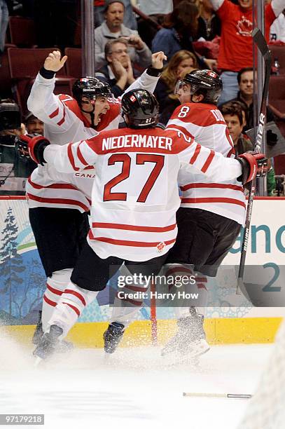 Sidney Crosby of Canada celebrates with teammates Scott Niedermayer and Drew Doughty after scoring the matchwinning goal in overtime during the ice...