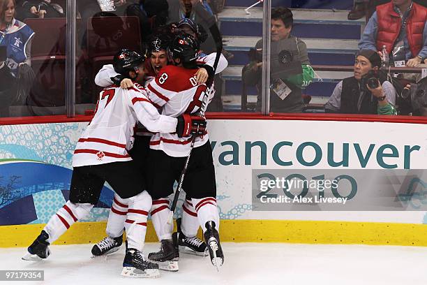 Sidney Crosby of Canada celebrates with teammates Scott Niedermayer and Drew Doughty after scoring the matchwinning goal in overtime during the ice...