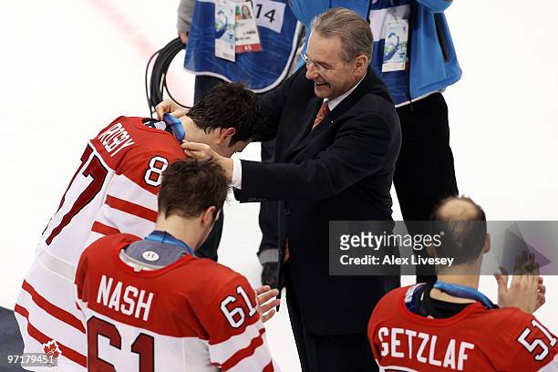 Sidney Crosby of Canada is presented his gold medal by IOC President Jacques Rogge following his team's 3-2 overtime win during the ice hockey men's...