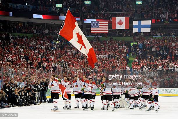 Team Canada celebrate after receiving their gold medals following their 3-2 overtime victory during the ice hockey men's gold medal game between USA...