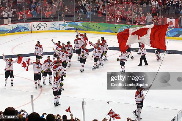 Sidney Crosby of Canada waves a national flag following his team's 3-2 overtime victory during the ice hockey men's gold medal game between USA and...