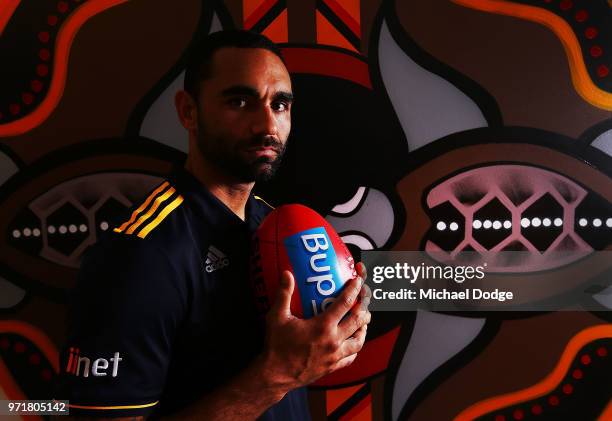 Shaun Burgoyne of the Hawthorn Hawks poses in front of an Indigenous artwork designed by teammate Cyril Rioli during a press conference at Waverley...