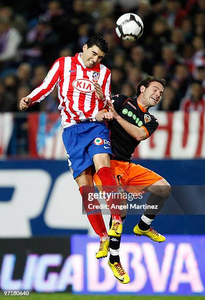 Jose Antonio Reyes of Atletico Madrid goes for a high ball against Juan Mata of Valencia during the La Liga match between Atletico Madrid and...