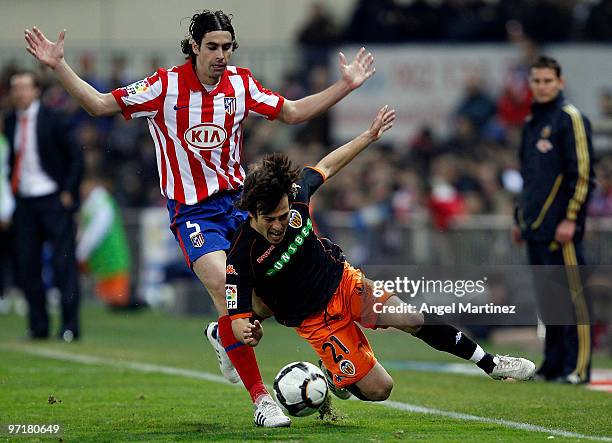 David Silva of Valencia is tackled by Tiago Cardoso of Atletico Madrid during the La Liga match between Atletico Madrid and Valencia at Vicente...