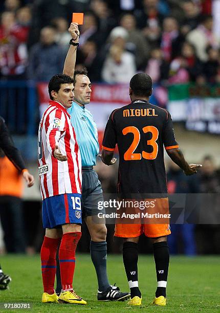 Referee Alfonso Perez Burrull shows a red card to Miguel Brito of Valencia during the La Liga match between Atletico Madrid and Valencia at Vicente...