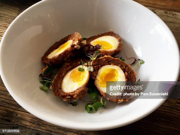 halved scotch eggs in a bowl - scotch egg stockfoto's en -beelden