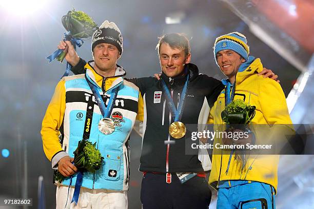 Axel Teichmann of Germany receives the silver medal, Petter Northug of Norway receives the gold medal and Johan Olsson of Sweden receives the bronze...