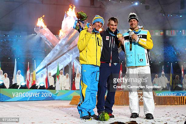 Axel Teichmann of Germany receives the silver medal, Petter Northug of Norway receives the gold medal and Johan Olsson of Sweden receives the bronze...