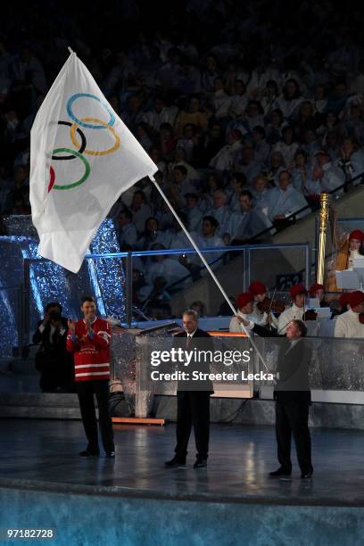 President Jacques Rogge passes the Olympic flag to Mayor of Sochi Anatoly Pakhomov as Mayor of Vancouver Gregor Robertson looks on during the Closing...