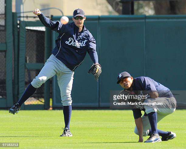 Don Kelly of the Detroit Tigers throws the baseball as Gustavo Nunez looks on during spring training workouts at Joker Marchant Stadium on February...
