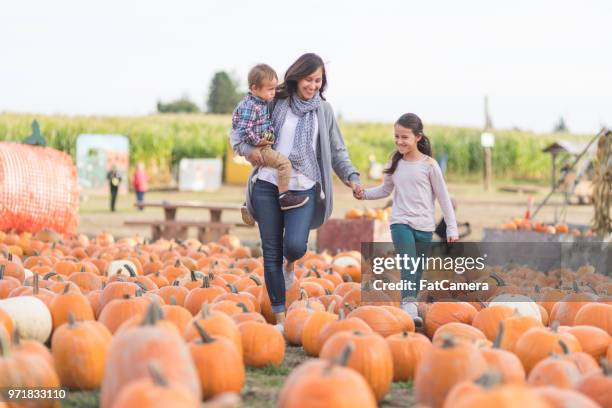 bella mamma etnica e le sue figlie nella fattoria della zucca! - festival tradizionale foto e immagini stock