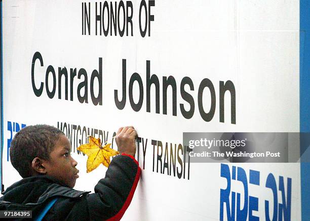 Jahi Chikwendiu/TWP Jordan Douglas, nephew of the last sniper victim Conrad Johnson, traces the words on the side of the bus at a memorial ceremony...