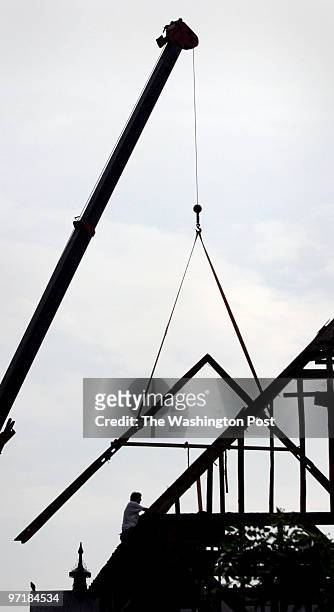Section of the roof A-frame is removed with a crane as continued de-construction of a 200 year old barn on the former Montjoy Farm site in Howard...