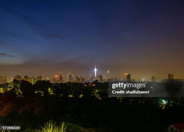 cloudy sunrise over kl tower and surrounded buildings in downtown kuala lumpur, malaysia. - shaifulzamri - fotografias e filmes do acervo