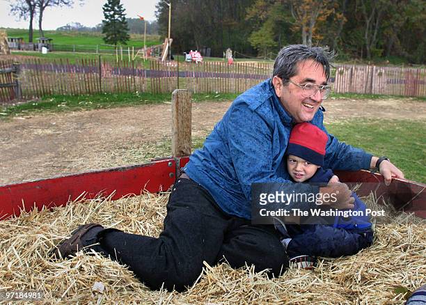 Robert Garafolo keeps his 4-year-old grandson Ryan Baxter warm as the weather got chilly during their hayride at Butler's Orchard.