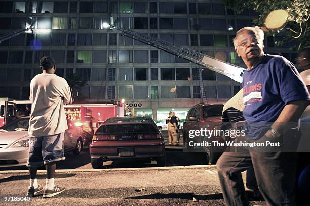 Displaced residents of this apartment building in the 1000th block of 6th street, SW, watch as firefighters work a fire on the fifth floor. The man...