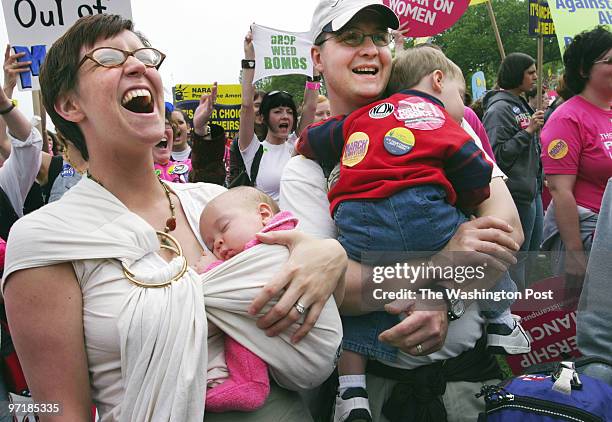 Crowd listens to speakers at rally on the mall before abortion rights march in DC. Catie and Jim Mehl of Ohio hold their children Lydia, 2 months old...