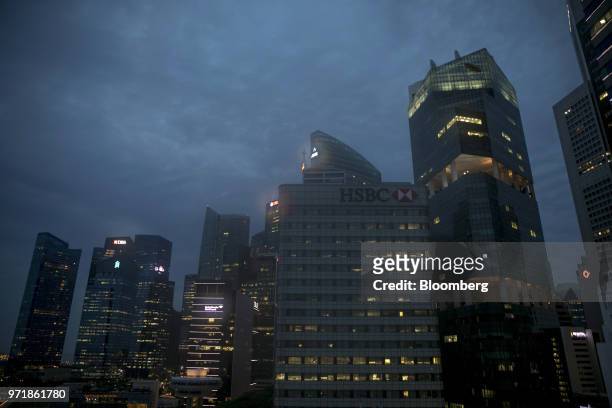 The HSBC Building, center, and other commercial buildings stand illuminated at dawn in Singapore, on Tuesday, June 12, 2018. President Donald...