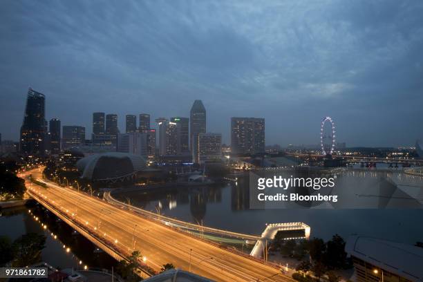 Light trails from passing traffic illuminate a road as buildings stand illuminated at dawn in Singapore, on Tuesday, June 12, 2018. President Donald...