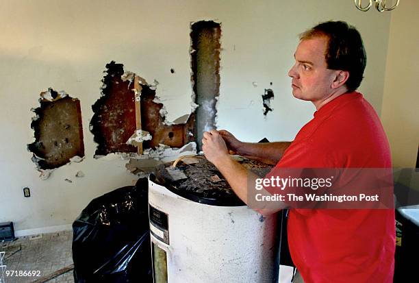 Credit: Michael Williamson/TWP Homeowner Eric Mackay in the kitchen area of his flooded home. The walls were opened up to dry the place out for fear...