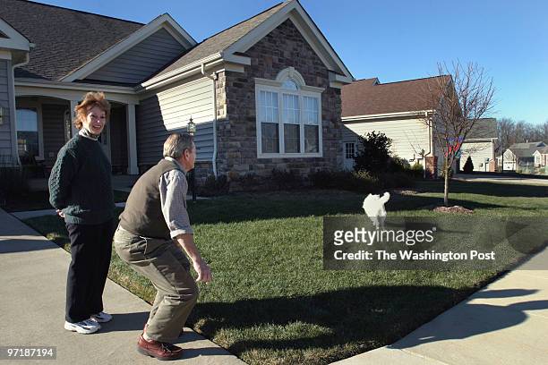 Lynn and Bob Levvis play with their dog Snowball at their home in Heritage Hunt. The upscale development has a golf course and a wide range of...