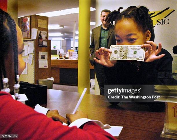 Photog: Gerald Martineau Jefferson-Houston Elem. School Alex, VA neg: 152139 kids run credit union Fourth grader Corretta Wright, left, writes a...