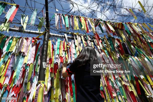 Visitor looks over a ribbon wishing for reunification of the two Koreas on the wire fence at the Imjingak Pavilion, near the demilitarized zone on...