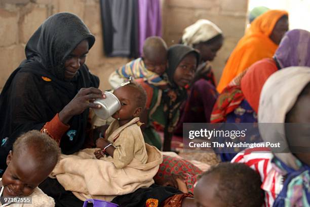 Jahi Chikwendiu/TWP Maka Arja from Kornoy, Sudan, feeds powdered milk to her 9-month-old child, Fatna Abdul Jabar, at the Ouri Cassoni refugee camp...