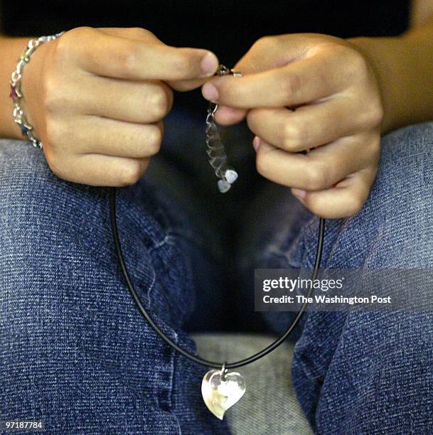 Hx-skuls26 08-18-04 Ellicott City, Md Mark Gail/TWP Hanny Kim holds a piece of jewerly given to her by her best friend before leaving Korea in March...