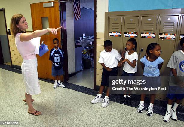 Teacher Corrine Massey gets her class of 1st, 2nd and 3rd graders lined up in the hallway at John Hanson Montessori in Temple Hills on the first day...