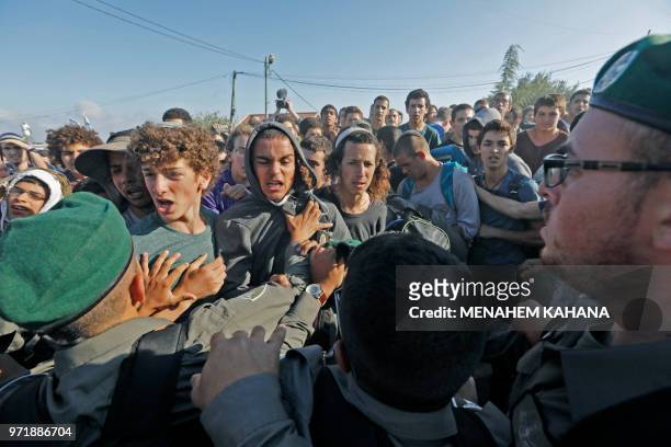 Israeli settlers scuffle with Israeli security forces at Netiv Haavot settlement, near Bethlehem, in the occupied West Bank on June 12, 2018. -...