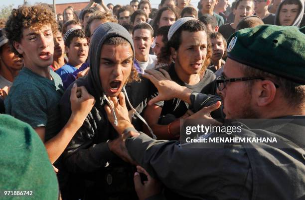 Israeli settlers scuffle with Israeli security forces at Netiv Haavot settlement, near Bethlehem, in the occupied West Bank on June 12, 2018. -...