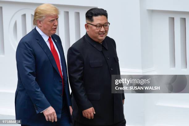President Donald Trump and North Korea leader Kim Jong Un walk from lunch at the Capella resort on Sentosa Island in Singapore on June 12, 2018. -...