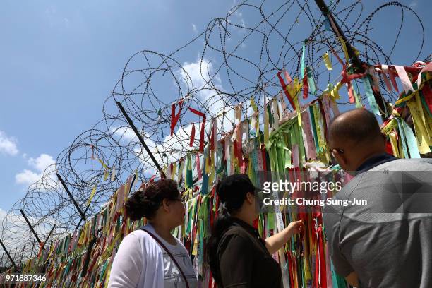 South Koreans read ribbons wishing for reunification of the two Koreas on the wire fence at the Imjingak Pavilion, near the demilitarized zone on...