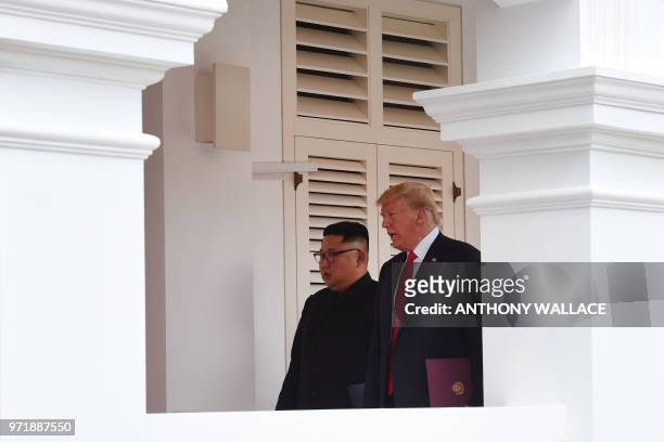 North Korea's leader Kim Jong Un walks out with US President Donald Trump to face the media after taking part in a signing ceremony at the end of...