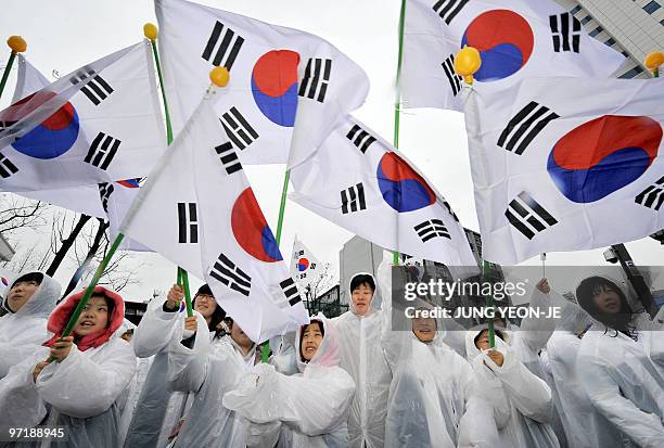 Students wave the South Korean national flag to celebrate the Independence Movement anniversary in Seoul on March 1, 2010. South Koreans marked the...