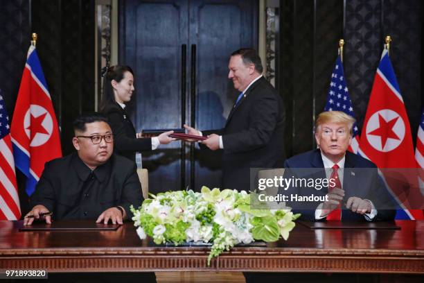 In this handout photograph provided by The Strait Times, North Korean leader Kim Jong-un with U.S. President Donald Trump during their historic...